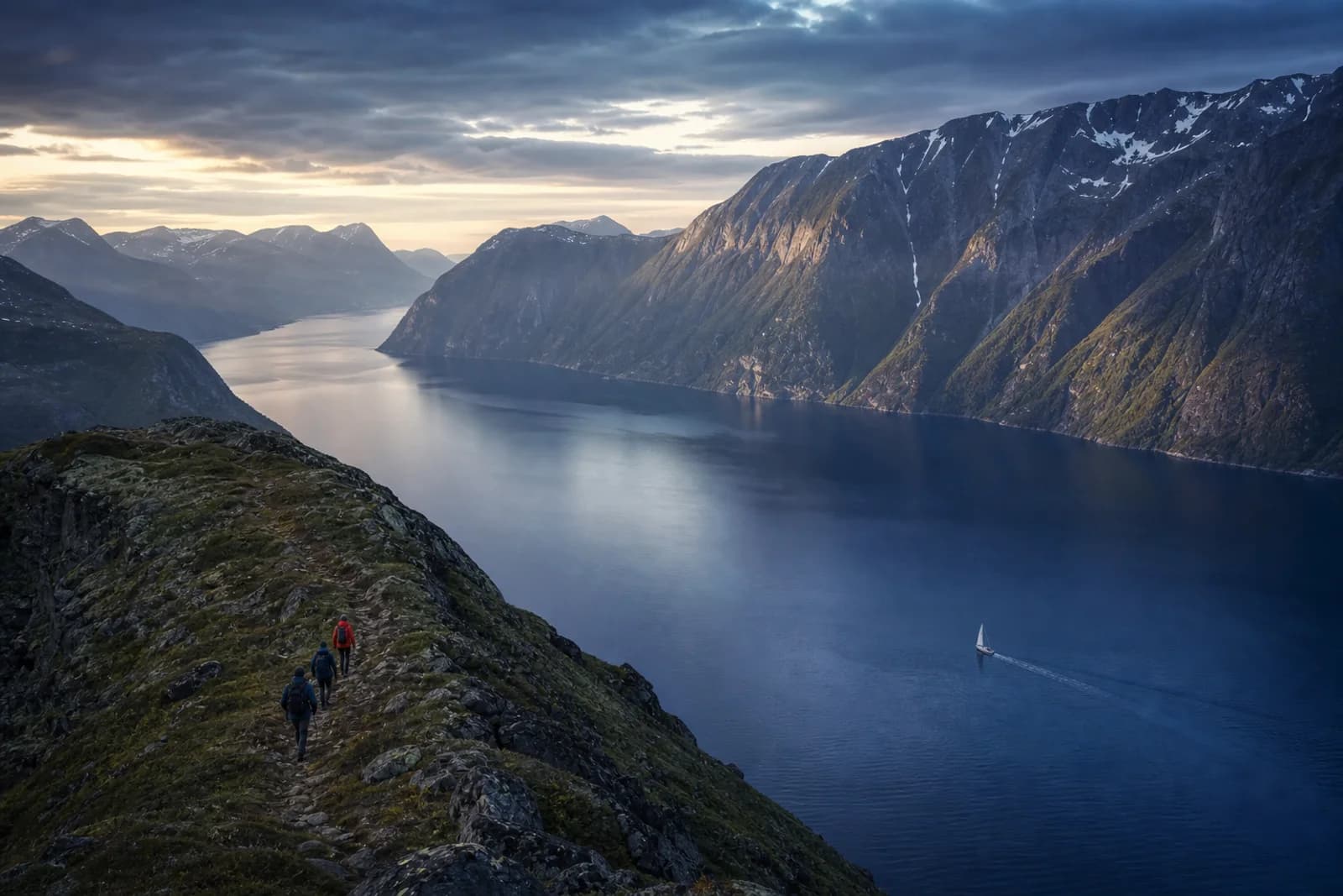 Guests hiking a ridge above a vast Norwegian fjord